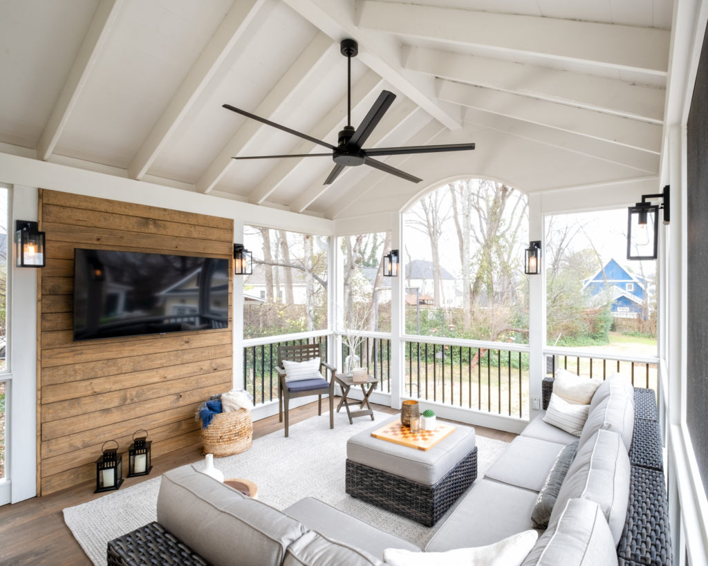 porch-screened-gable-roof-exposed-ceiling-fan-accent-wall-wood-tv-cypress-flooring-wood-spindle-columns